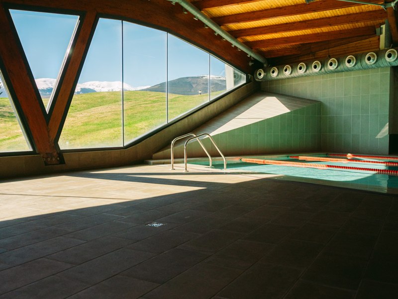 Bassin intérieur sous une charpente en bois — Fontanals Golf Club