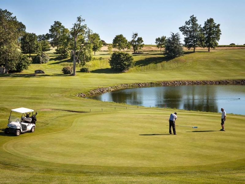 Green de golf, lac et golfeurs