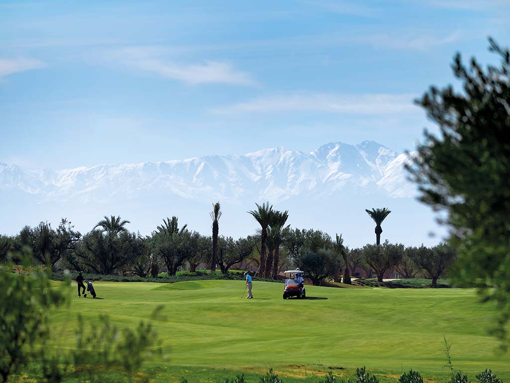 Golfeur, green et vue splendide sur le montagne enneigée