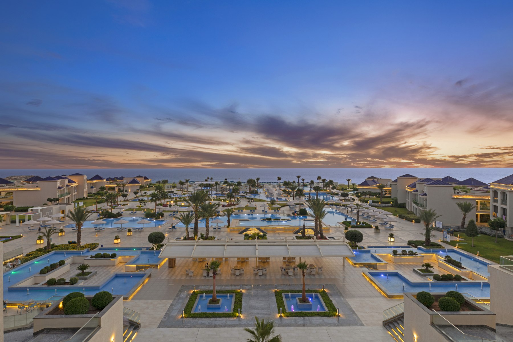 Piscines et bâtiments éclairés au crépuscule au White Beach Resort Taghazout