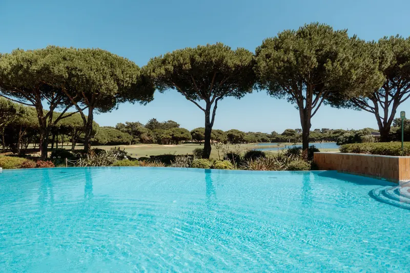 Piscine extérieure et pins face au golf du Kimpton Quinta da Marinha Cascais