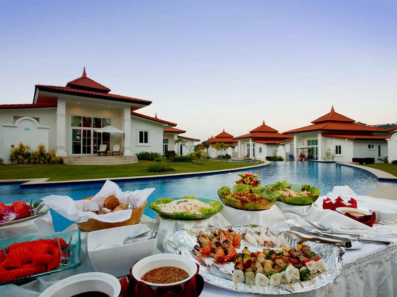 Petit-déjeuner au bord de la piscine, devant les bungalows